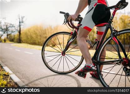 Bycyclist in helmet and sportswear on bike workout. Cycling on bike path, training on asphalt road. Bycyclist in helmet and sportswear on bike workout