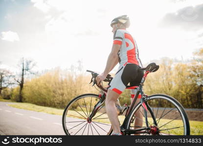 Bycyclist in helmet and sportswear on bike workout. Cycling on bike path, training on asphalt road