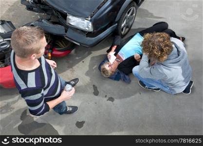 Bystanders providing first aid to an injured woman at the scene of a car crash