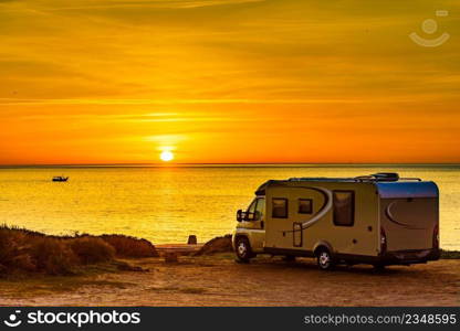 C&er rv at sunrise on mediterranean coast Costa del Sol, Andalucia Spain. C&ing on nature beach. Vacation and trip in motor home.. C&er vehicle on beach at sunrise