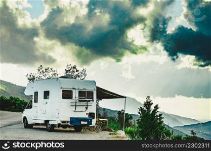 C&er vehicle with roll out awning and tourist table with chairs in french mountains. C&ing on nature. Holidays and travel with motor home.. C&er c&ing in mountain