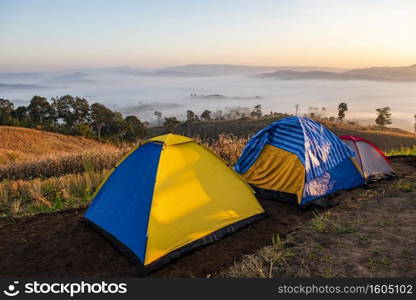 C&ing tent area on mountain, tourist tent c&ing with fog mist landscape sunrise beautiful in winter view outdoor travel