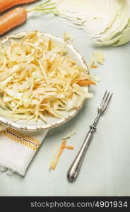 cabbage carrots salad in plate with fork, close up
