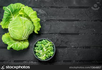 Cabbage salad in a bowl. On black rustic background.. Cabbage salad in a bowl.