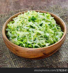 Cabbage salad in wooden bowl, selective focus, square