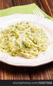 Cabbage salad - shredded fresh cabbage with dill on a plate. The Cabbage salad