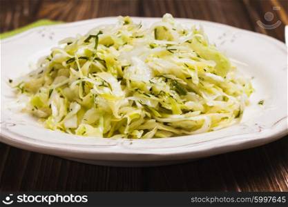 Cabbage salad - shredded fresh cabbage with dill on a plate. The Cabbage salad