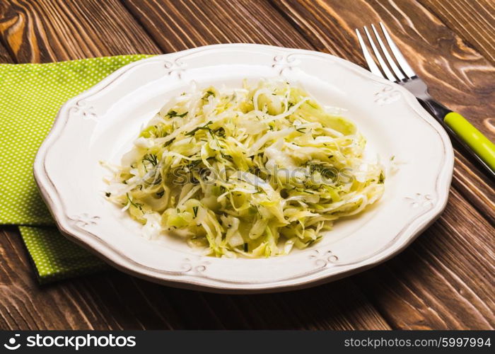 Cabbage salad - shredded fresh cabbage with dill on a plate. The Cabbage salad