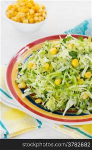Cabbage salad with corn on plate, selective focus