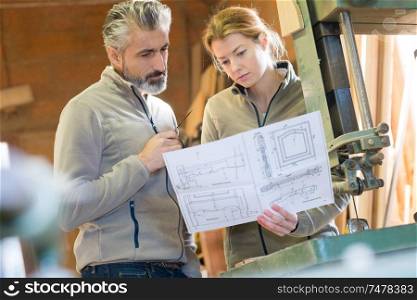 cabinet makers looking at project drawings