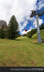 cablaway over meadow and wood in Italian Dolomites