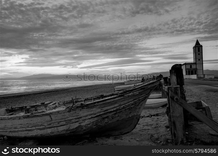 Cabo de Gata in Almeria at San Miguel Beach and Salinas church with stranded boats at sunset