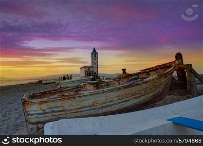 Cabo de Gata in Almeria at San Miguel Beach and Salinas church with stranded boats at sunset