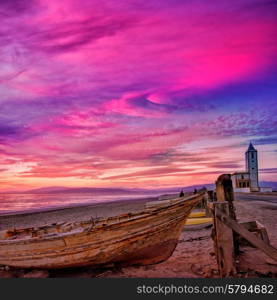 Cabo de Gata in Almeria at San Miguel Beach and Salinas church with stranded boats at sunset