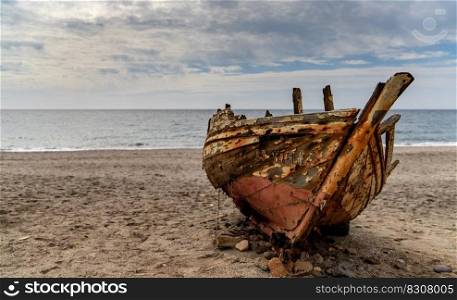 Cabo de Gata, Spain - 3 March, 2022  old abandonend beached wooden fishing boat on a beach in Andalusia
