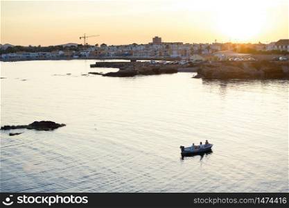 Cabo de Palos, Spain, May, 2020: Three friends relaxing at a boat in the seascape of Cabo de Palos in Murcia coast, Spain, during sunset.. Cabo de Palos, Spain, May, 2020: Three friends relaxing at a boat in the seascape of Cabo de Palos in Murcia coast, Spain, during sunset