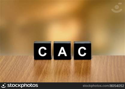 CAC or customer acquisition cost on black block with blurred background
