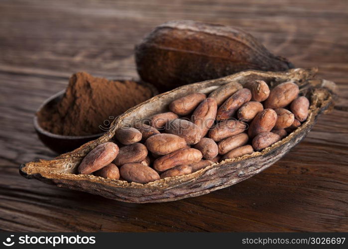 Cacao beans and powder and food dessert background. Cocoa beans in the dry cocoa pod fruit on wooden background