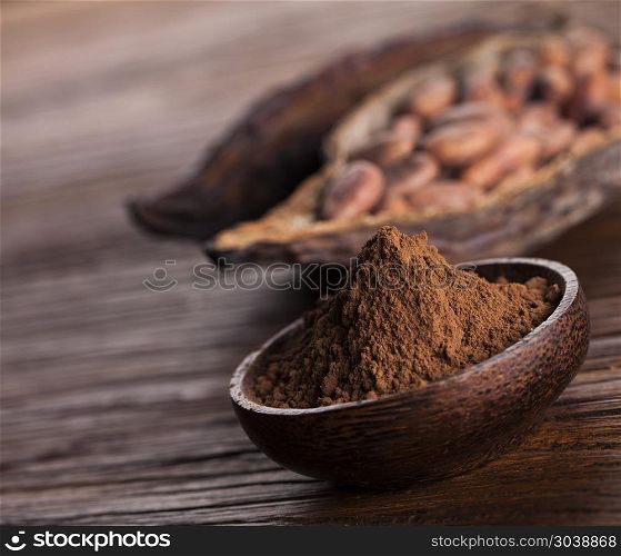 Cacao beans and powder and food dessert background. Cocoa beans in the dry cocoa pod fruit on wooden background