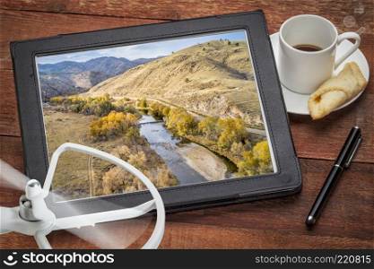 Cache la Poudre River at a canyon mouth above Fort Collins, Colorado in a  fall scenery, reviewing an aerial image on a digital tablet