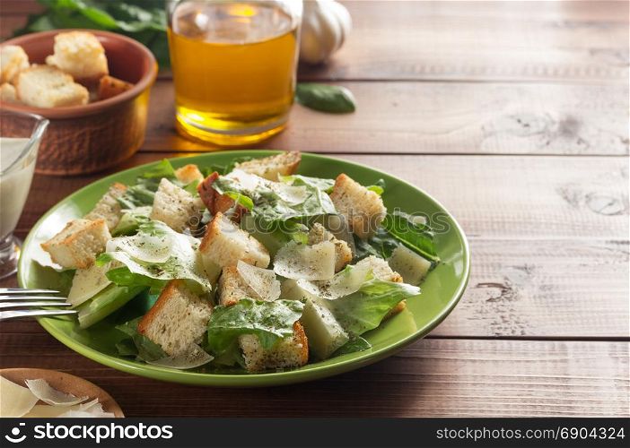 caesar salad and ingredients at wooden background