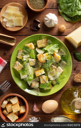 caesar salad in plate at wooden background