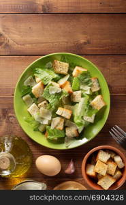 caesar salad in plate at wooden background