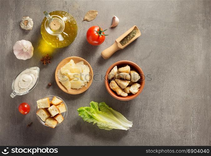 caesar salad ingredients at stone table background