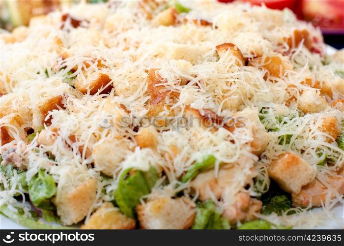 Caesar salad on a plate sprinkled with grated cheese