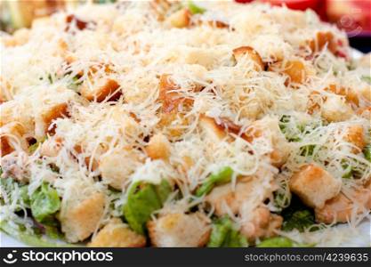 Caesar salad on a plate sprinkled with grated cheese