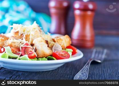 caesar salad on plate and on a table