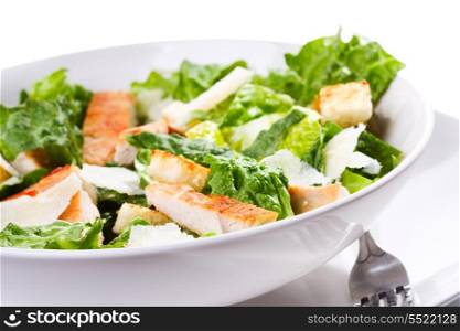 Caesar salad with chicken and greens on white background