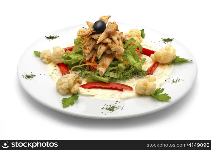 caesar salad with lettuce, chicken meat, red pepper, cauliflower, carrot and one black olive. caesar salad