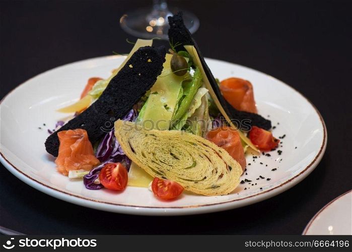 Caesar salad with salmon fish. Tasty restaurant dish. Caesar salad with salmon fish