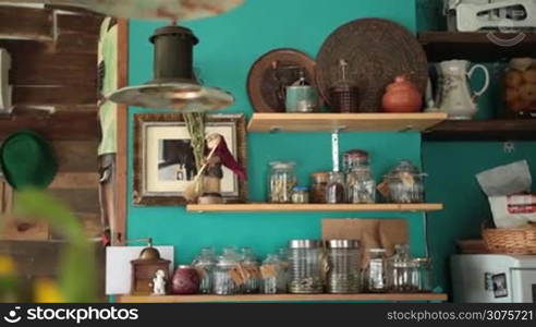 Cafe&acute;s wooden shelves with various food ingredients and utensils. In the end focus on sunflowers.