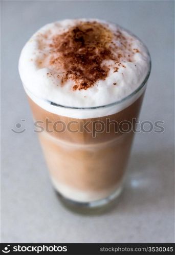 Cafe - Coffee Latte with cacao powder in a tall glass on bright background