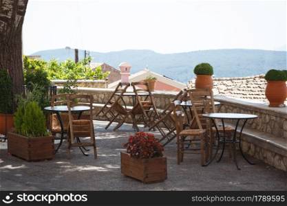 cafe on the square of a small town. tables and chairs with Mountain View. island of Corfu, Greece