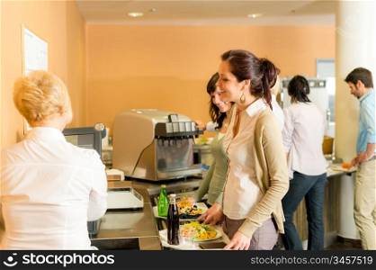 Cafeteria woman pay at cashier hold serving tray fresh food
