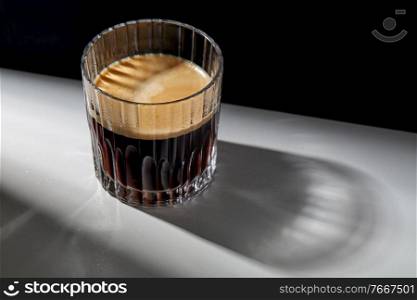 caffeine, objects and drinks concept - glass of coffee on table. glass of coffee on table