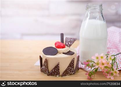 Cake and a bottle of milk on a wooden table in warm light, Vintage tone, Space to write.