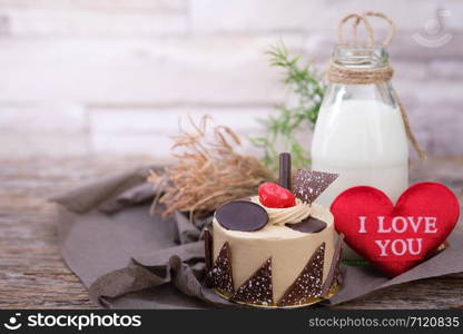 Cake and a bottle of milk on a wooden table in warm light, Vintage tone, Space to write, Valentine concept.