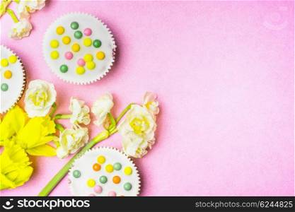 Cake and daffodils flowers on pink background, top view, place for text. Easter bake