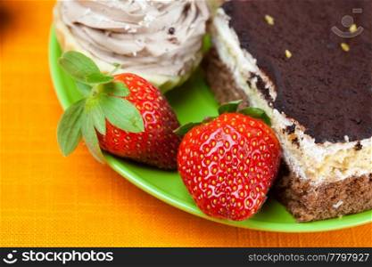 cake and strawberries lying on the orange fabric