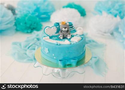 Cake for the first birthday of a boy with a bear in blue.