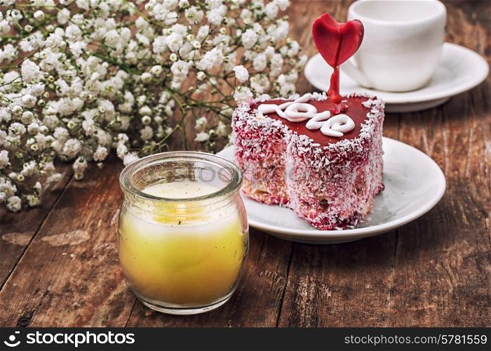 cake in the shape of heart with the inscription love and bunch of berries
