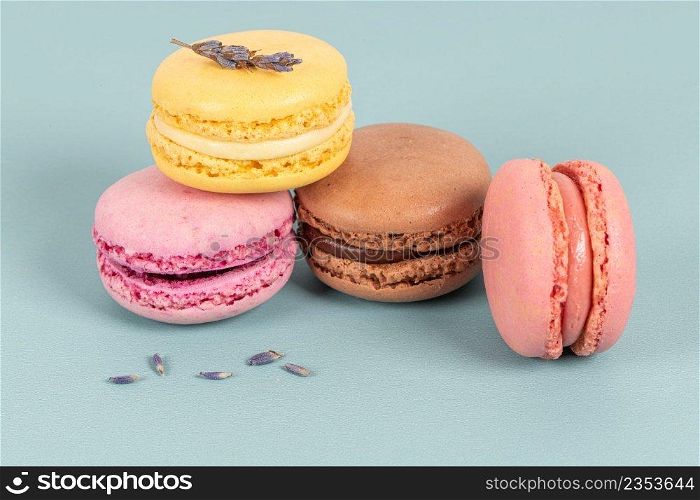 Cake macaron or macaroon on turquoise background from above, colorful almond cookies, pastel colors, vintage card