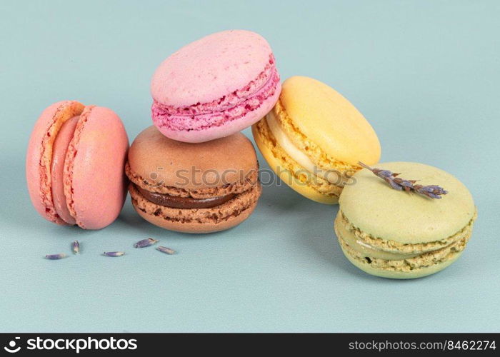 Cake macaron or macaroon on turquoise background from above, colorful almond cookies, pastel colors, vintage card