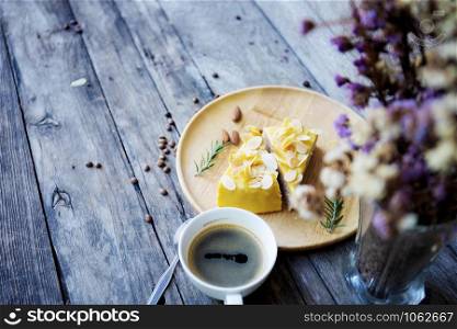 Cake on tray and coffee cup with wooden background.