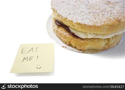 Cake slice with &acute;eat me&acute; sign on sticky notepaper