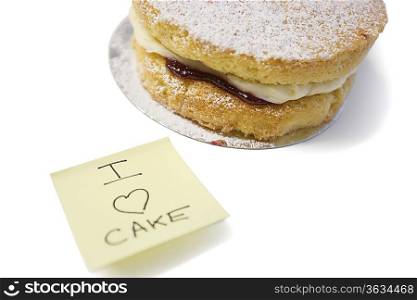 Cake slice with &acute;I love cake&acute; sign on sticky notepaper